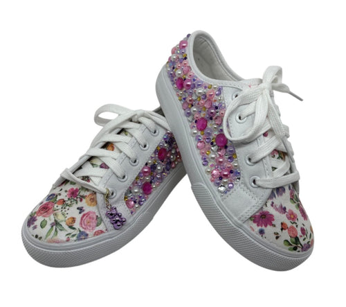 White sneakers with floral pattern and colorful embellishments on a white background